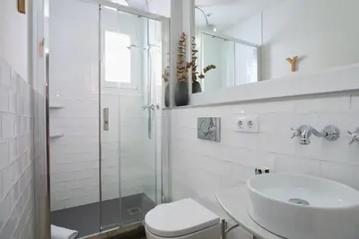 a white bathroom with a sink and a toilet at Casa Cosi - Putxet 2 in Barcelona