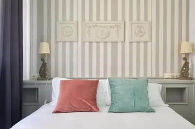 a bed with three pillows on top of it at Casa Cosi - Sant Gervasi 2 in Barcelona
