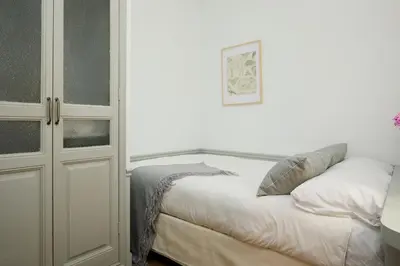 a white bedroom with a bed and a cabinet at Casa Cosi - Sant Gervasi 2 in Barcelona
