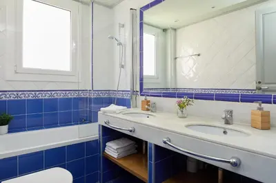 a bathroom with two sinks and a tub and a mirror at Casa Cosi - Sant Gervasi 2 in Barcelona
