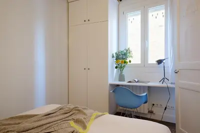 a bedroom with a bed and a desk and a blue chair at Casa Cosi - Sant Gervasi 4 in Barcelona