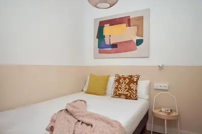 a bedroom with a white bed with a blanket on it at Casa Cosi - Sant Gervasi 4 in Barcelona