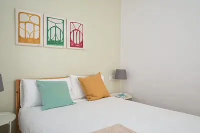 a bedroom with a white bed with colorful pillows at Casa Cosi - Francoli 4 in Barcelona