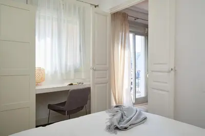 a bedroom with a bed and a desk and a chair at Casa Cosi - Francoli 4 in Barcelona