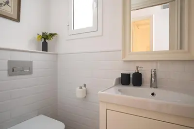 a white bathroom with a sink and a mirror at Casa Cosi - Francoli 4 in Barcelona