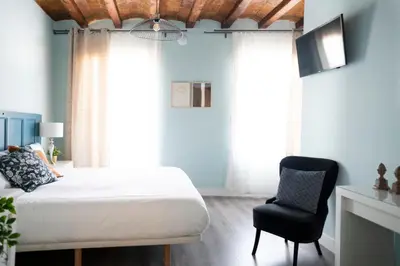 a bedroom with a bed and a chair at Casa Cosi - La Gleva 3 in Barcelona