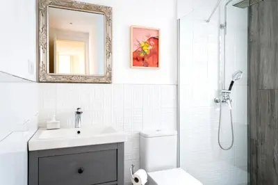 a bathroom with a sink and a shower with a mirror at Casa Cosi - La Gleva 3 in Barcelona