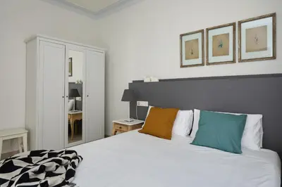 a bedroom with a large white bed with colorful pillows at Casa Cosi - Casanova 4 in Barcelona