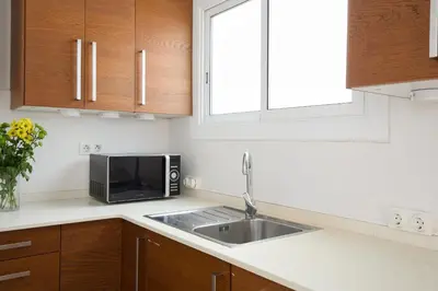 a kitchen with a sink and a microwave at Casa Cosi - Casanova 4 in Barcelona