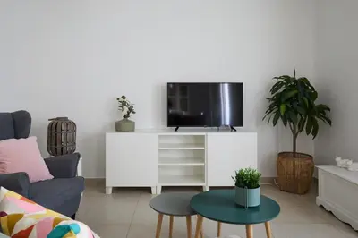 a living room with a tv on a white cabinet at Casa Cosi - Casanova 4 in Barcelona