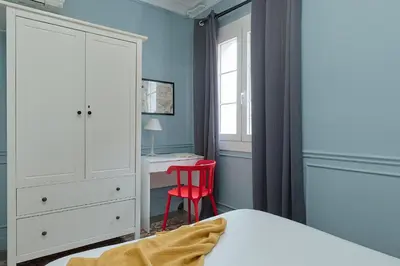 a bedroom with a bed and a red chair at Casa Cosi - El Farro 1 in Barcelona