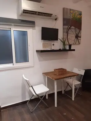 a room with a table and chairs and a tv at 09 Apartament born 4 2 in Barcelona