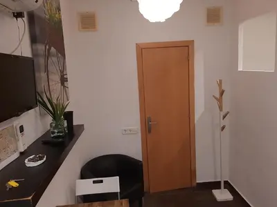 a room with a chair and a wooden door at 09 Apartament born 4 2 in Barcelona