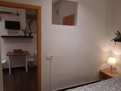 a bedroom with a door and a table and a desk at 09 Apartament born 4 2 in Barcelona
