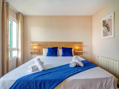 a bedroom with a large bed with blue pillows at Balmins Surf by Hello Homes Sitges in Sitges