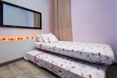 two beds in a room with a mirror at Paseo de Gracia Apartments in Barcelona