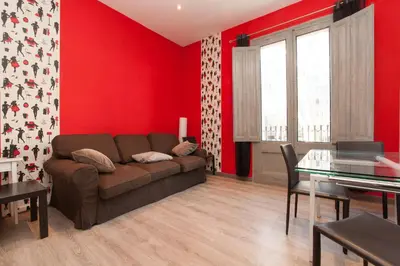 a living room with a brown couch and red walls at Paseo de Gracia Apartments in Barcelona