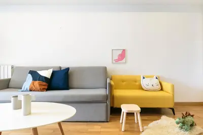a living room with a couch and a yellow chair at Sardenya Apartment by Olala Homes in Barcelona