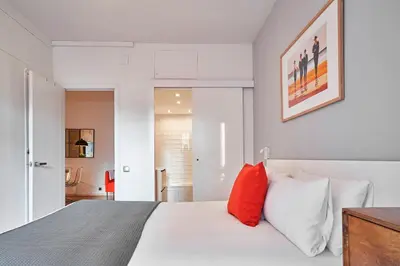 a bedroom with a white bed with red pillows at Love Local Life Near Sagrada Familia by MyRentalHost in Barcelona