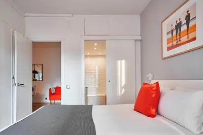 a bedroom with a white bed with a red pillow at Love Local Life Near Sagrada Familia by MyRentalHost in Barcelona