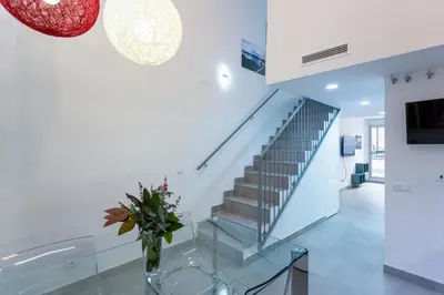 a staircase with a glass table and a vase of flowers at 8 lacus duplex in Hospitalet de Llobregat