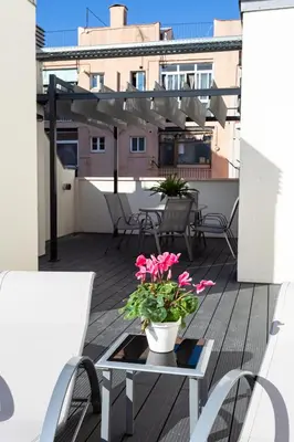 a patio with a table and flowers on a balcony at 8 lacus duplex in Hospitalet de Llobregat