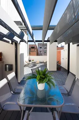 a balcony with a glass table and chairs at 8 lacus BAIKAL in Hospitalet de Llobregat