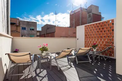 a patio with chairs and tables on a balcony at 8 lacus BAIKAL in Hospitalet de Llobregat