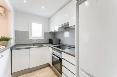 a kitchen with white cabinets and a sink at Feel Welcome Barcelona Smart flat in Cornellà de Llobregat