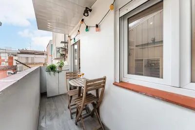 a wooden chair sitting on a balcony next to a window at Feel Welcome Barcelona Smart flat in Cornellà de Llobregat
