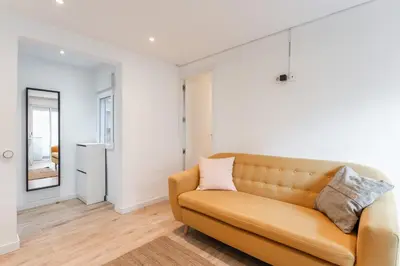 a living room with a couch and a mirror at Feel Welcome Barcelona Smart flat in Cornellà de Llobregat