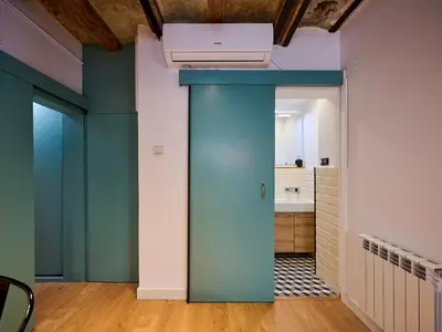 a room with a blue door and a kitchen at Casa Wilson by MyRentalHost in Barcelona