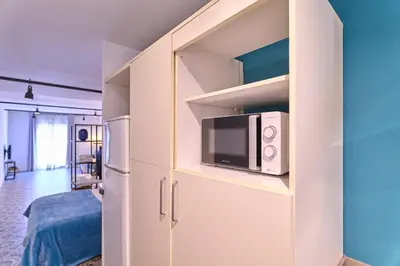 a white cabinet with a microwave in a room at Liceu Apartments by gaiarooms in Barcelona