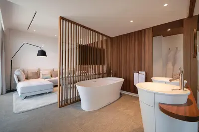 a bathroom with a tub and two sinks and a couch at Hotel Marina Badalona in Badalona