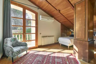 a bedroom with a bed and a chair and a window at Villa Marco in Canyelles
