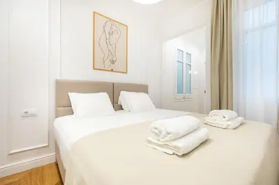 a white bedroom with two towels on a bed at Majestic 4BR/4BATH apartment in Sagrada Familia area in Barcelona