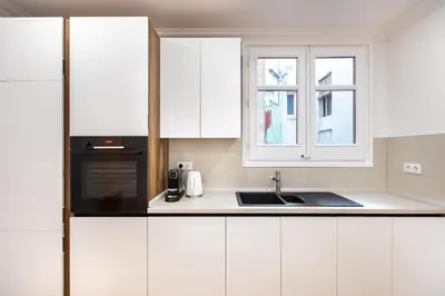 a kitchen with white cabinets and a sink and a window at Majestic 4BR/4BATH apartment in Sagrada Familia area in Barcelona