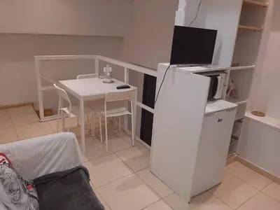 a small kitchen with a table and a white refrigerator at 06 DUPlEX LOFT in Barcelona