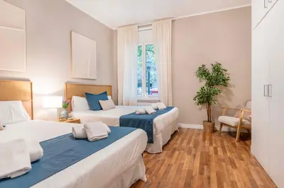 a bedroom with two beds and a potted plant at Sagrada familia Secret Apartment in Barcelona
