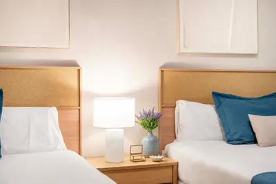 a bedroom with two beds with blue and white pillows at Sagrada familia Secret Apartment in Barcelona