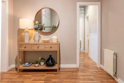 a hallway with a table with a mirror on it at Sagrada familia Secret Apartment in Barcelona