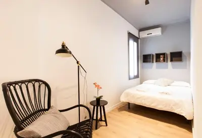 a bedroom with a bed and a chair and a lamp at 1521 - AB Sagrada Família Comfort in Barcelona