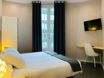 a bedroom with a bed and a desk and a window at Super Balmes Guest House in Barcelona