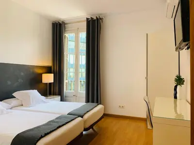 a hotel room with a bed and a window at Super Balmes Guest House in Barcelona