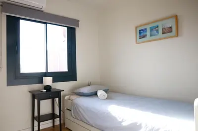 a small bedroom with a bed and a window at Amazing sea and Sagrada Familia views homey apartment in Barcelona