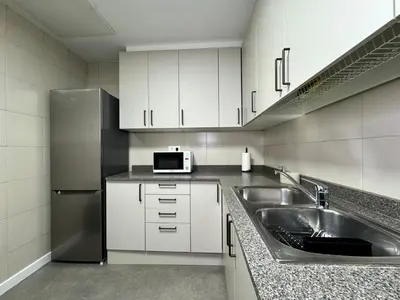 a kitchen with a sink and a refrigerator at Anais Apartments by gaiarooms in Barcelona