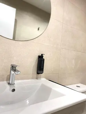 a bathroom sink with a soap dispenser and a mirror at Anais Apartments by gaiarooms in Barcelona