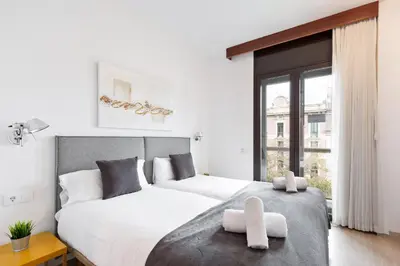 a bedroom with two beds and a large window at Stay U-nique Apartments Sant Antoni II in Barcelona