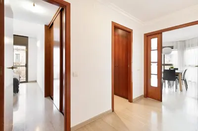a hallway with white walls and wooden doors at Stay U-nique Apartments Sant Antoni II in Barcelona