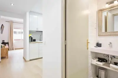 a white bathroom with a sink and a mirror at Apartment Eduardo in Barcelona